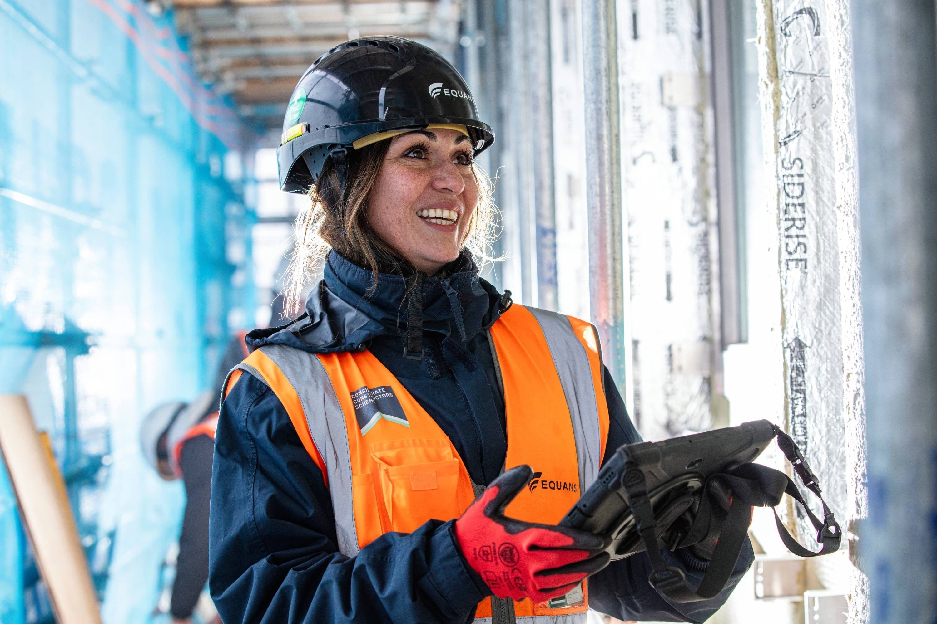 Equans project engineer in a hard hat and hi-vis jacket on site